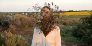 Eine Frau mit einem Herzförmigen Strauß Wiesenblumen